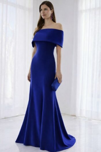 Woman in a royal blue off-the-shoulder evening gown, floor-length, holding a matching blue clutch.