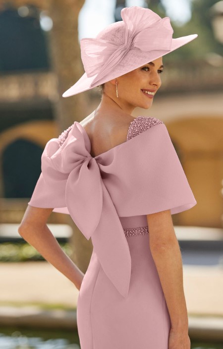 8G153 5 - Sofi Designs Bridal Woman in a pale pink dress with a large bow on the back, wearing a matching wide-brim hat outdoors.